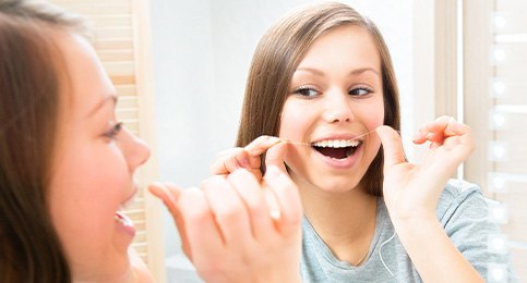 Woman flossing her teeth