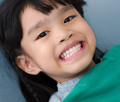 Child smiling after fluoride treatment