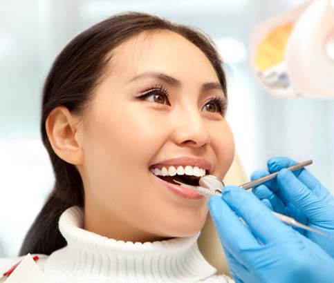 Woman preventing dental emergencies in Reno by visiting her dentist