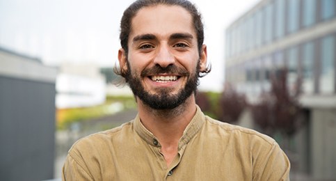 person smiling with their arms crossed