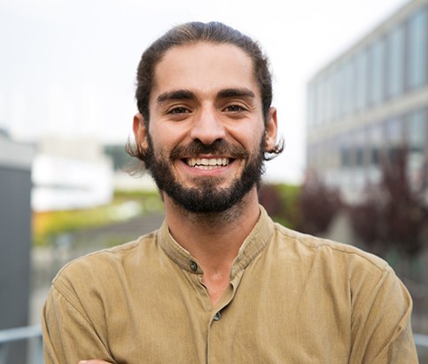 Man outside in city smiling with dental implants in Reno, NV