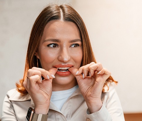 Patient putting on clear aligner in treatment room