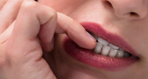 closeup of woman biting her fingernails  