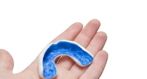 closeup of person holding mouthguard  