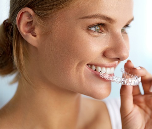 Woman placing Invisalign tray