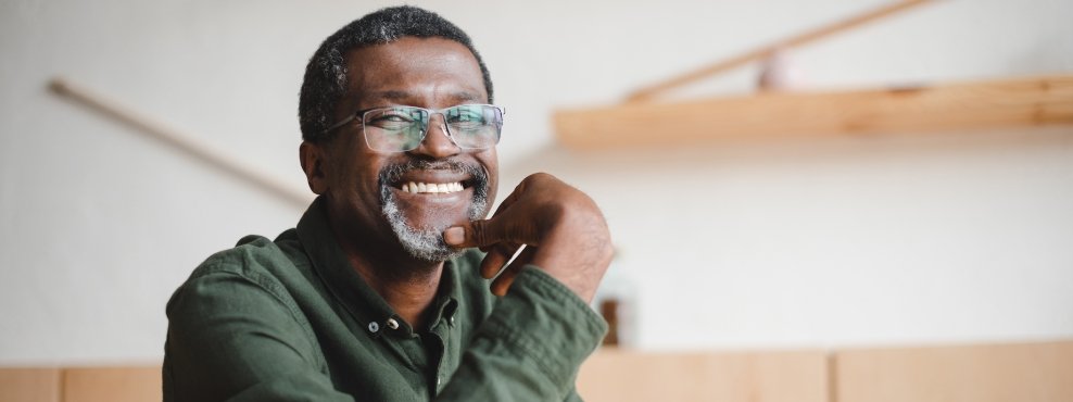 Older man smiling after replacing missing teeth