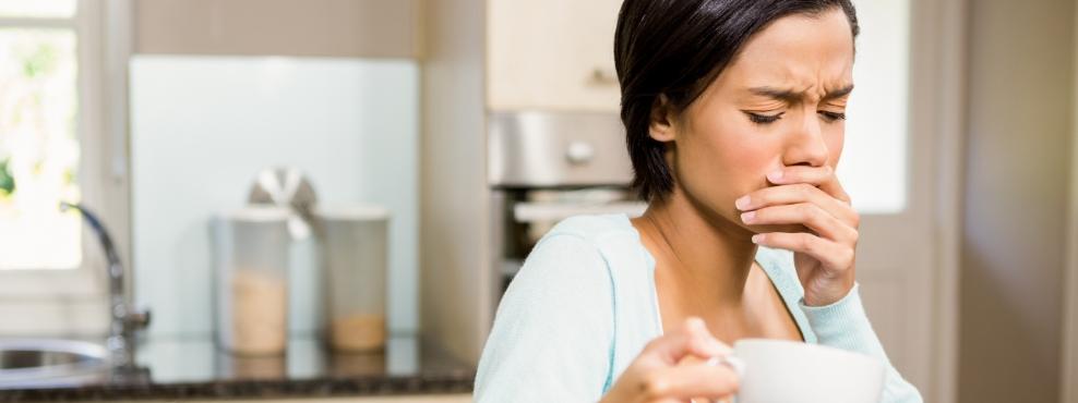 Woman in need of emergency dentistry covering her mouth in pain