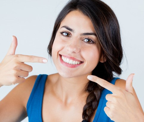 Girl with brighter teeth and pointing at her smile   
