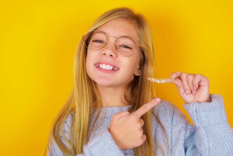 girl holding Invisalign tray in Reno